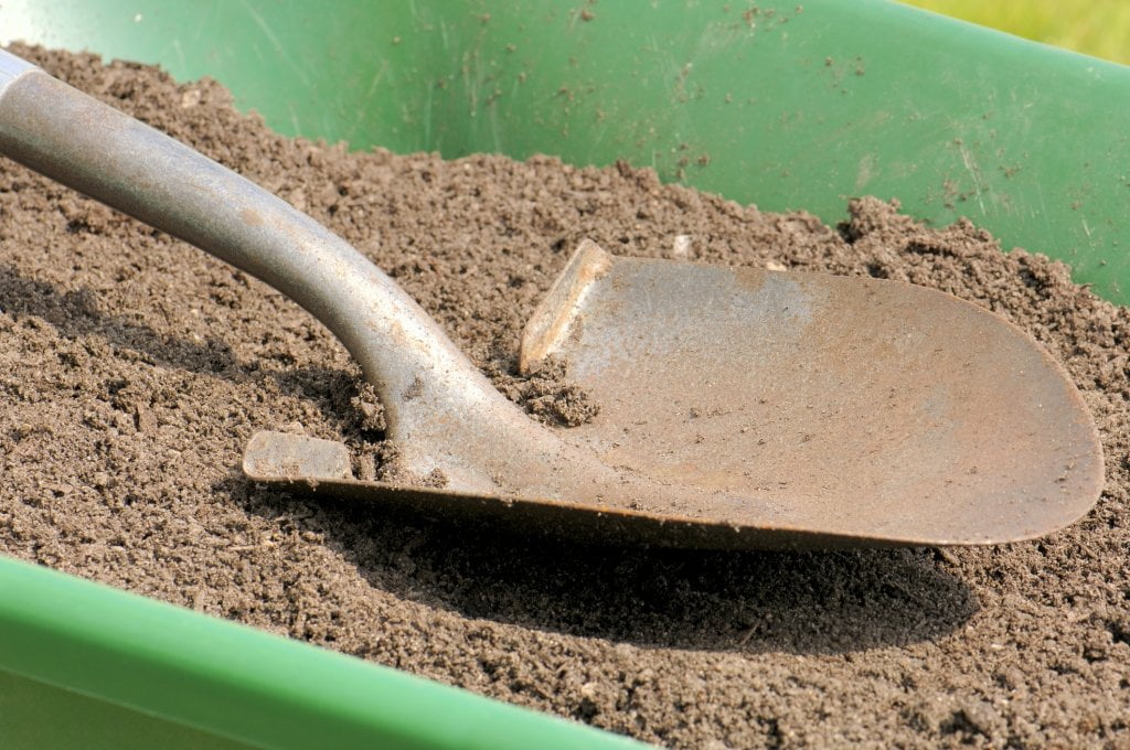 Topsoil and shovel in wheelbarrow for instant lawn