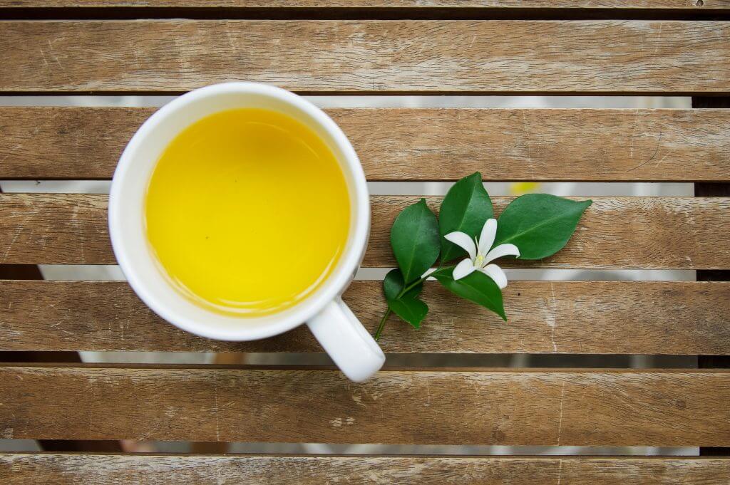 A cup of orange jasmine tea on a wooden table